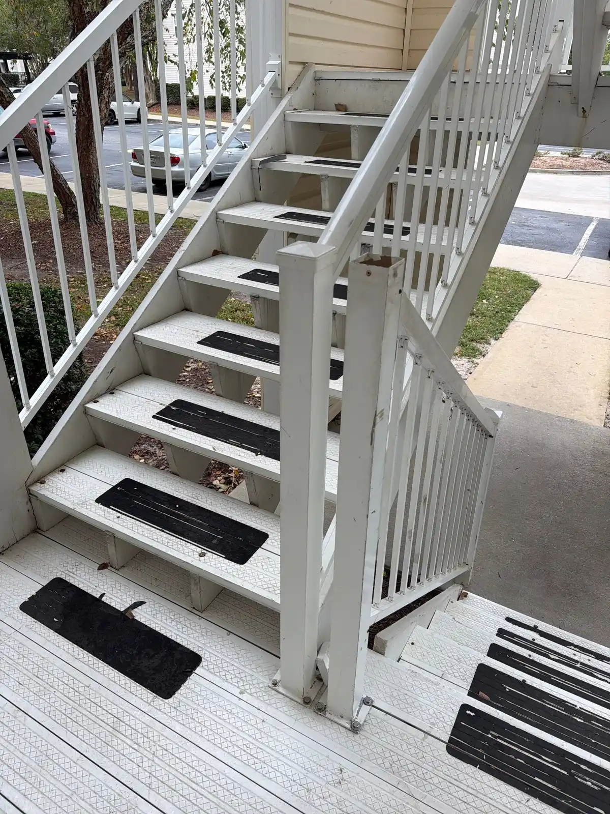 Exterior apartment stairway with composite treads before repairs