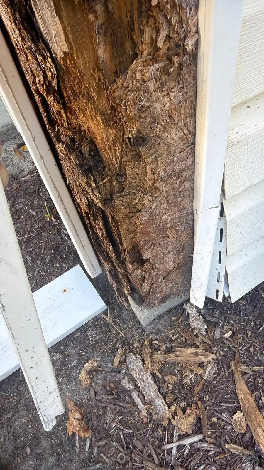 Wood support post rotted at its base next to the stairway